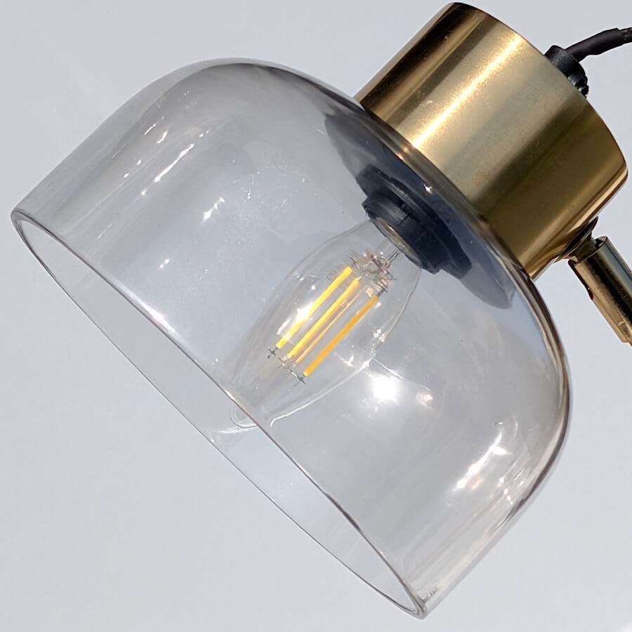 Focus sur l'ampoule E14 visible à travers l'abat-jour en verre fumé.