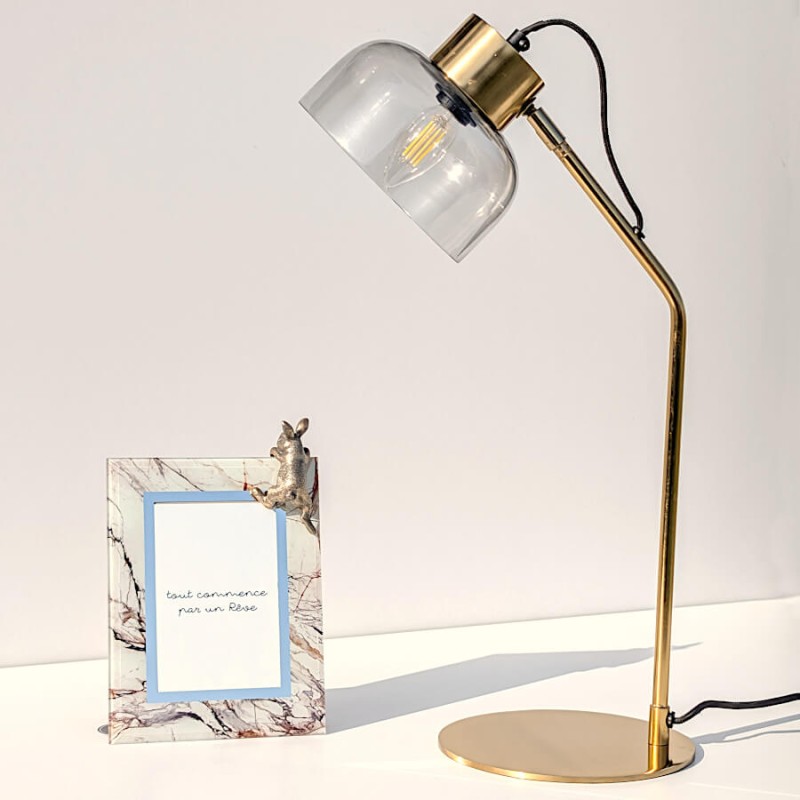 La lampe vue de face sur un plan de travail, soulignant sa finesse.