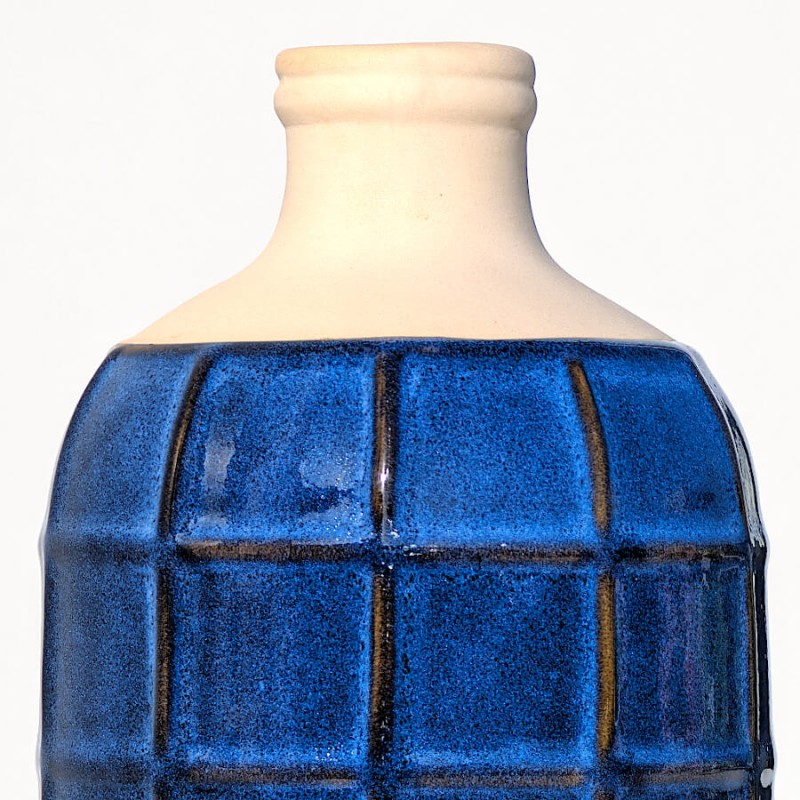 Zoom sur le col en grès blanc cassé et le haut du motif quadrillé.