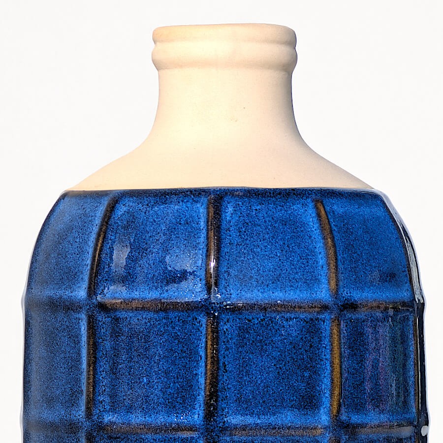 Zoom sur le col en grès blanc cassé et le haut du motif quadrillé.