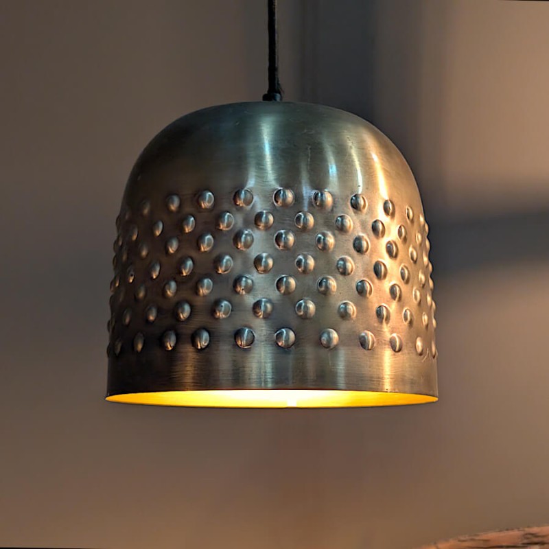 Mise en scène chic du luminaire diffusant une lumière dorée vers le bas.