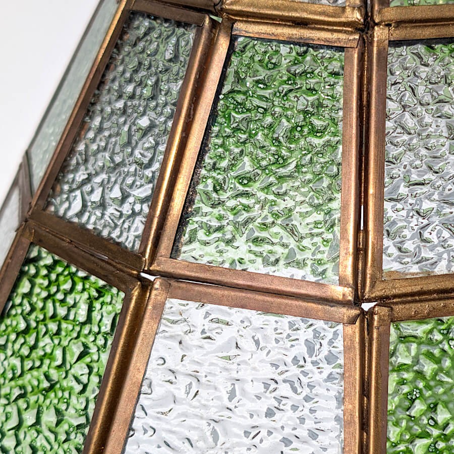 Zoom sur le verre martelé laissant deviner ses reflets et sa transparence.