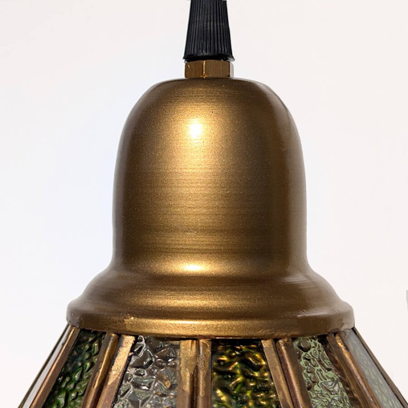 Gros plan sur la tête du luminaire en métal à la finition laiton brossé.