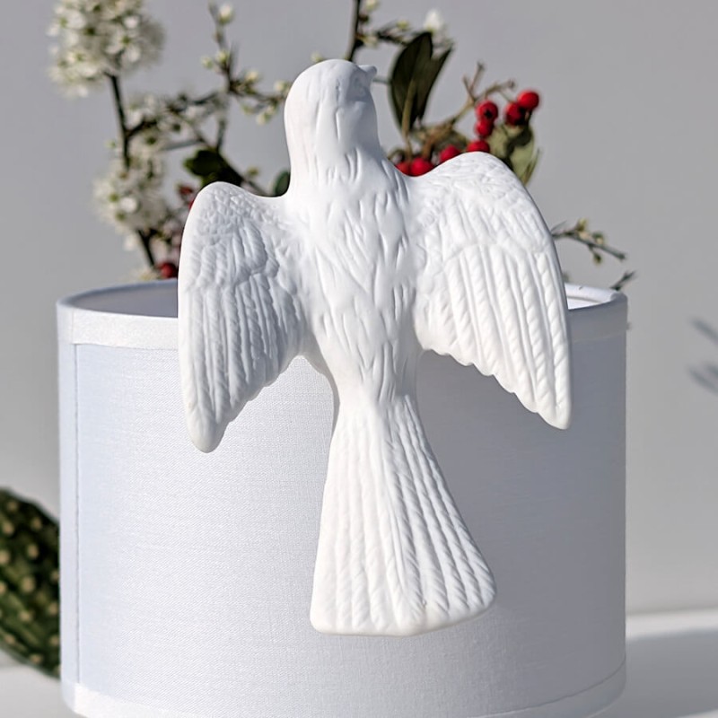Focus sur la colombe et son travail de sculpture sur un abat-jour blanc.
