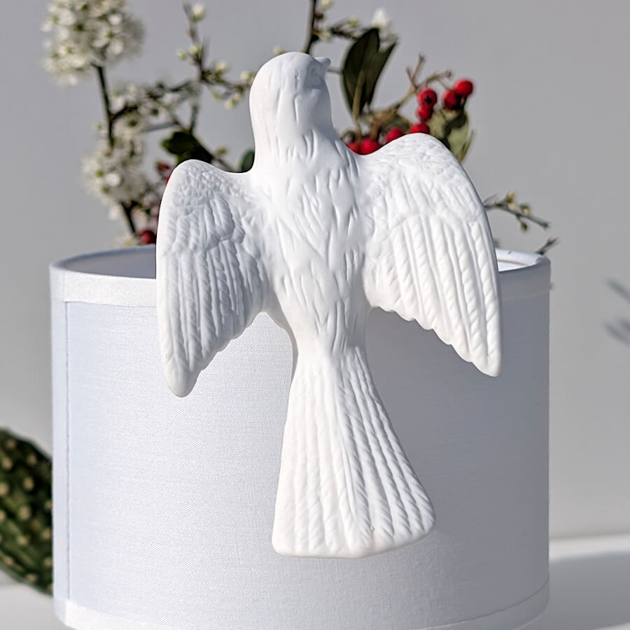 Focus sur la colombe et son travail de sculpture sur un abat-jour blanc.