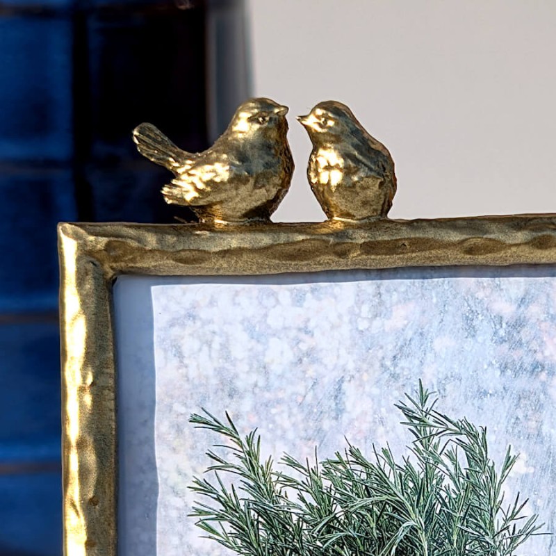 Zoom sur le couple d'oiseaux sculptés au sommet du cadre.