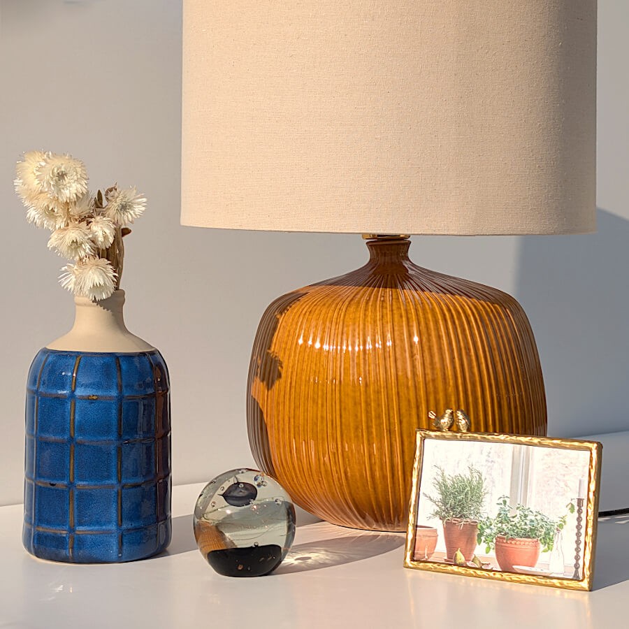 Le cadre intégré dans une composition avec le vase bleu, le sulfure Galaxie et la lampe ocre Deco-Delight.