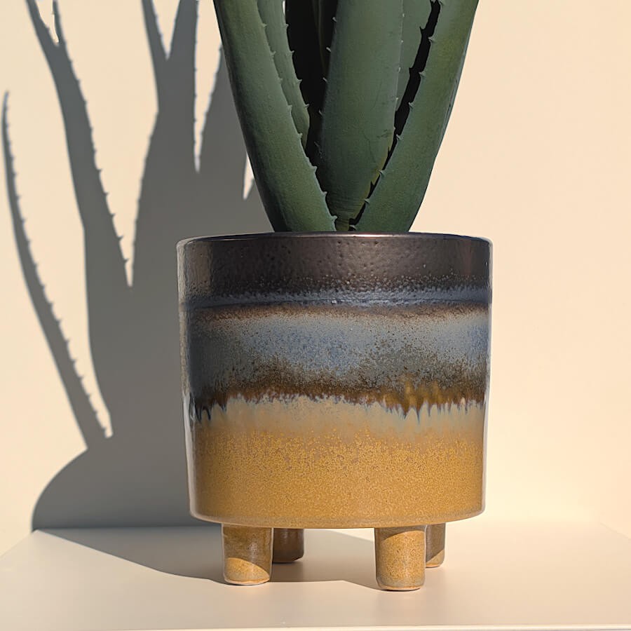 Vue d'ensemble du pot sur ses 4 pieds, évoquant l'image du chaudron.