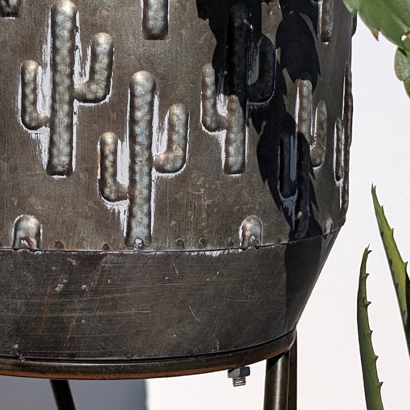 Focus sur la texture en relief du métal embouti révélant la répétition du motif cactus.