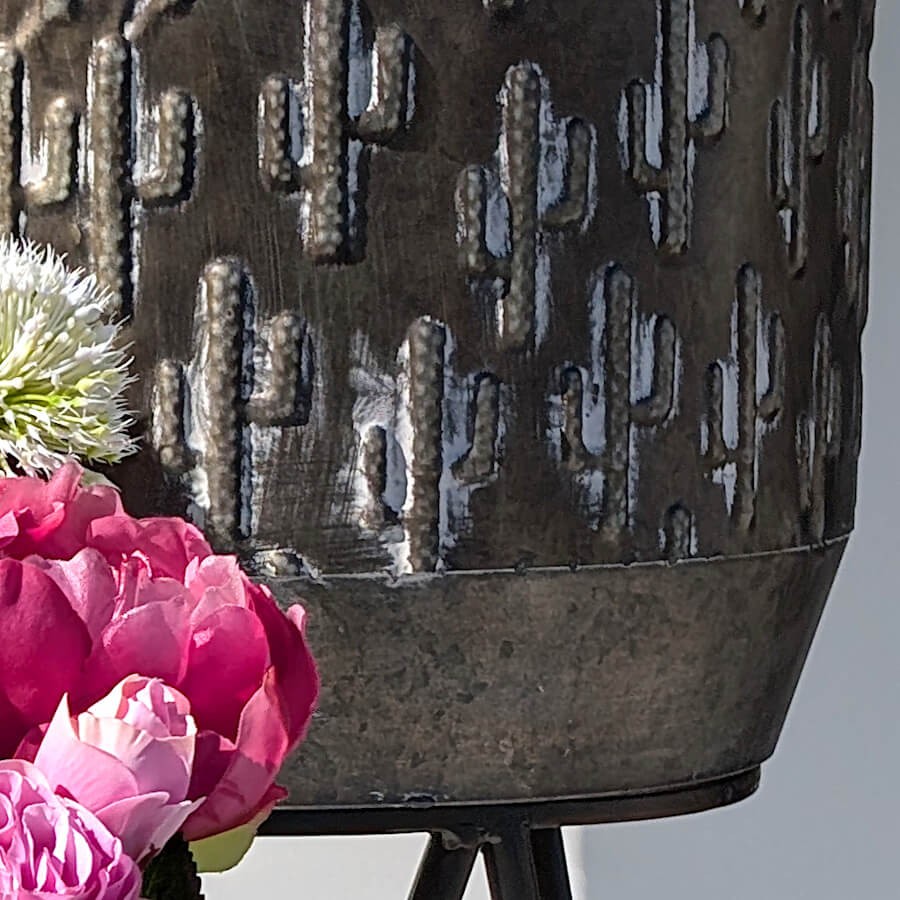 Zoom sur le relief précis des cactus en métal en relief.