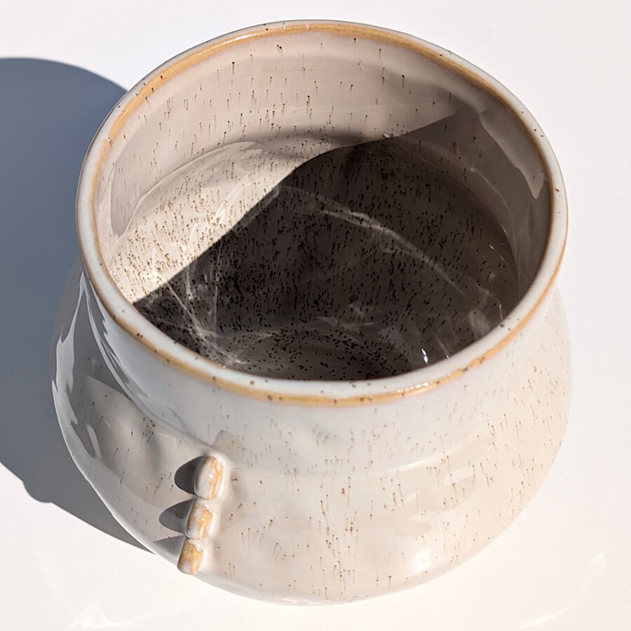 Vue plongeante montrant l'ouverture et la texture intérieure du pot sous le soleil.