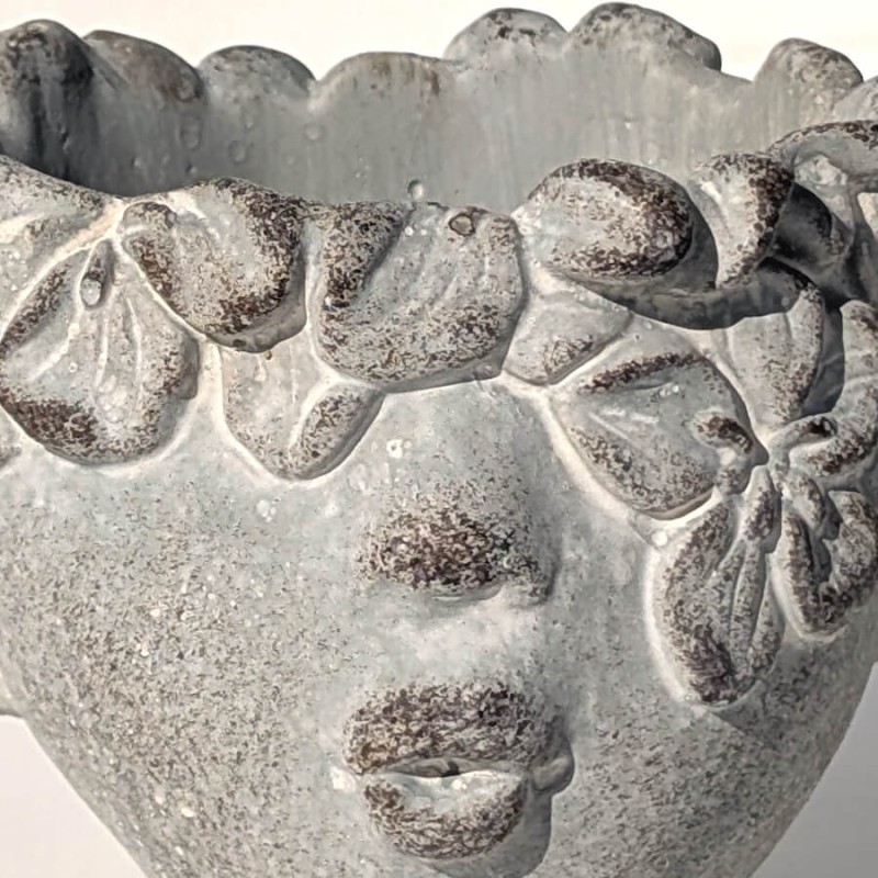 Détail de la couronne de fleurs sculptée sur le front.