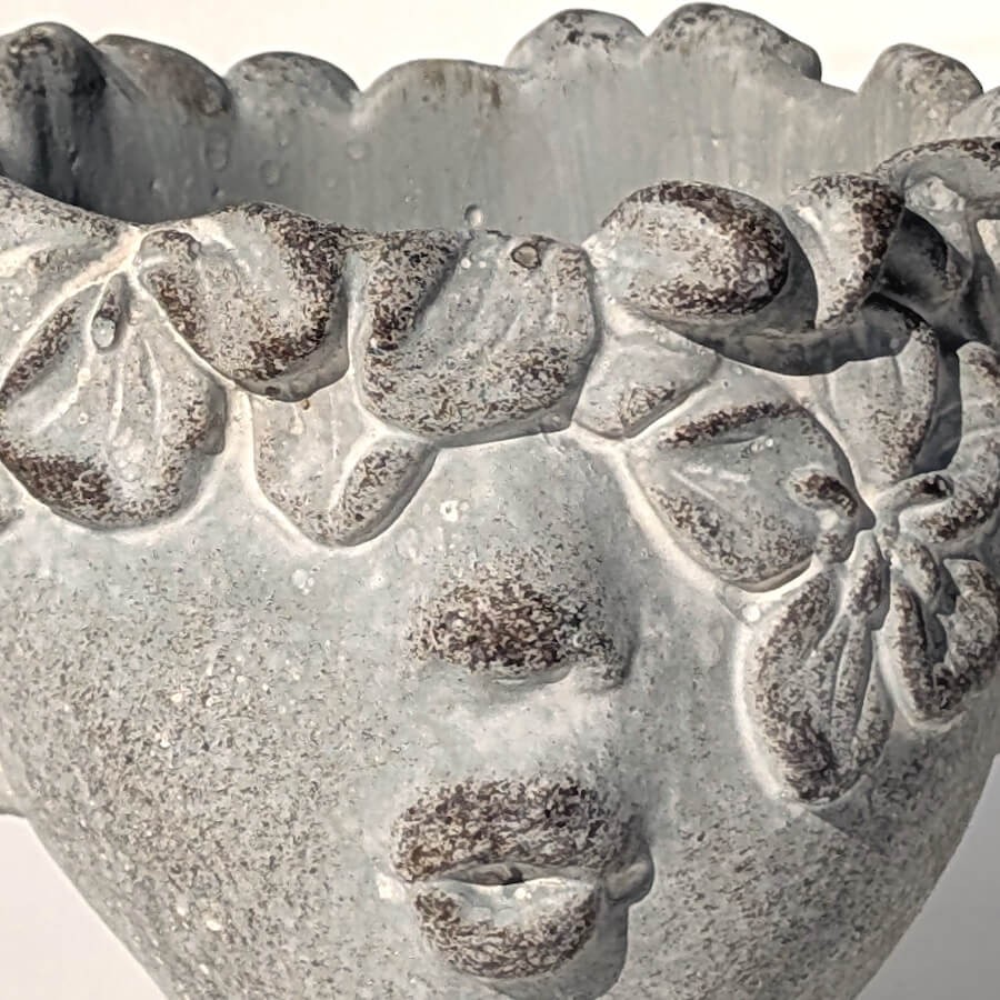 Détail de la couronne de fleurs sculptée sur le front.