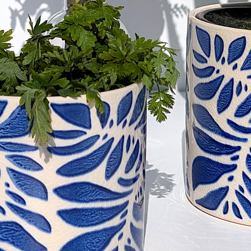 Zoom sur les détails du motif végétal aux contours nets et l'émaillage brillant.