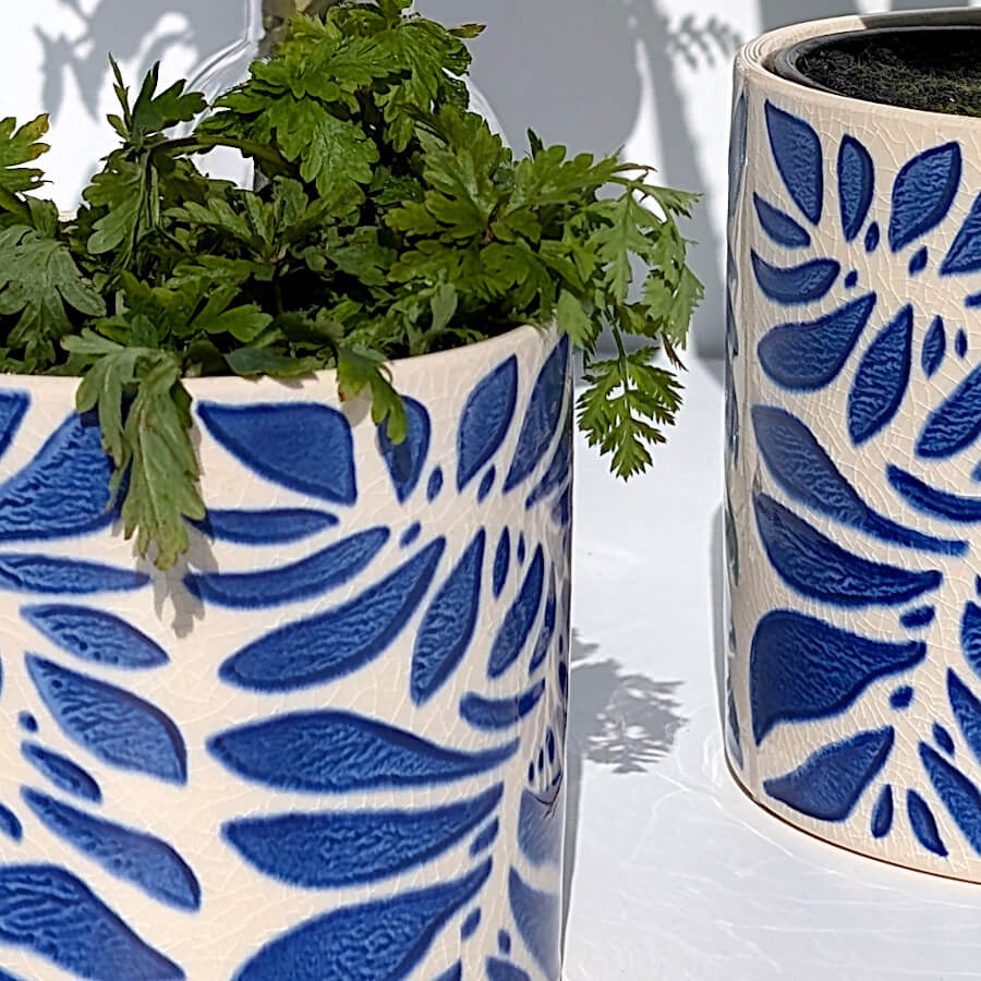 Zoom sur les détails du motif végétal aux contours nets et l'émaillage brillant.