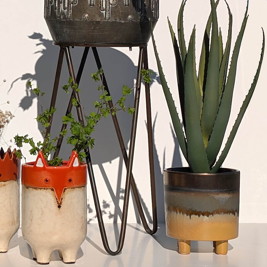 Mise en scène chaleureuse avec le cache-pot en grès dégradé jaune/marron.