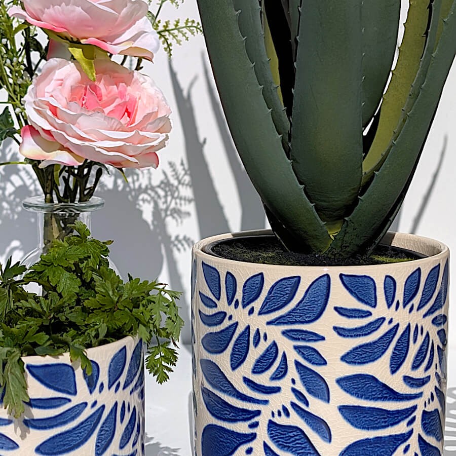 L'Aloe Vera dans un cache-pot céramique bleu grec à côté d'un bouquet de fleurs artificielles, pour un effet printanier.