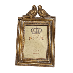 Portrait frontal du cadre mettant en valeur les deux moineaux sculptés au sommet.