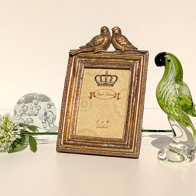 Mise en scène épurée avec une statuette perroquet en verre et quelques fleurs d'allium artificielles Deco-Delight.