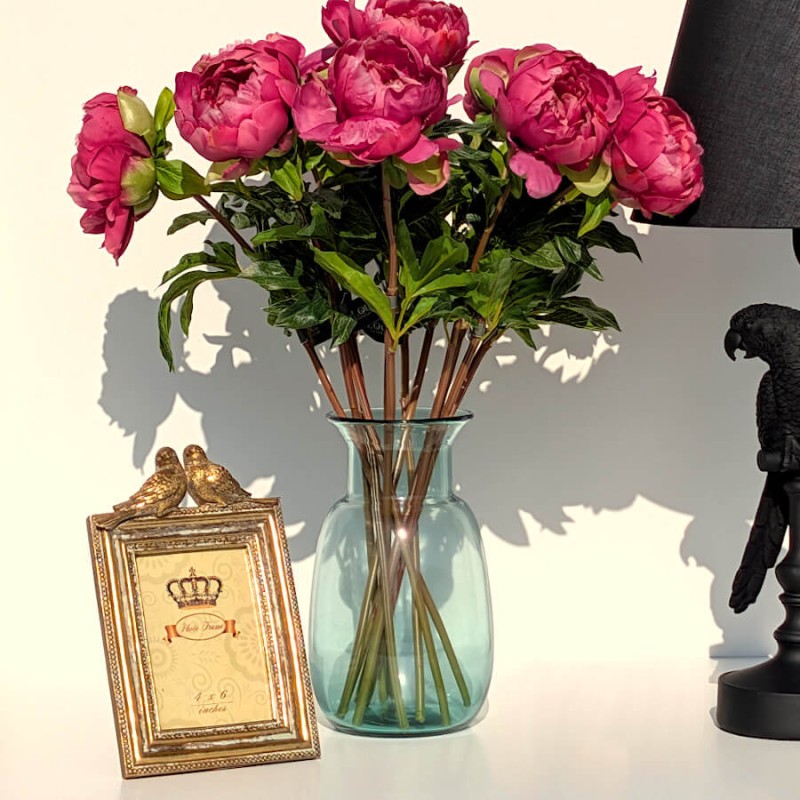 Le cadre à côté d'un vase bleu et d'un bouquet de fleurs pour un look printanier.