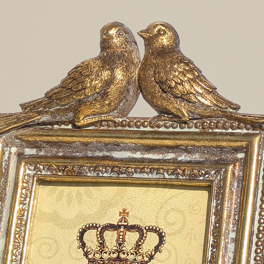 Gros plan sur les oiseaux moineaux amoureux pour apprécier la sculpture de ce cadre romantique.