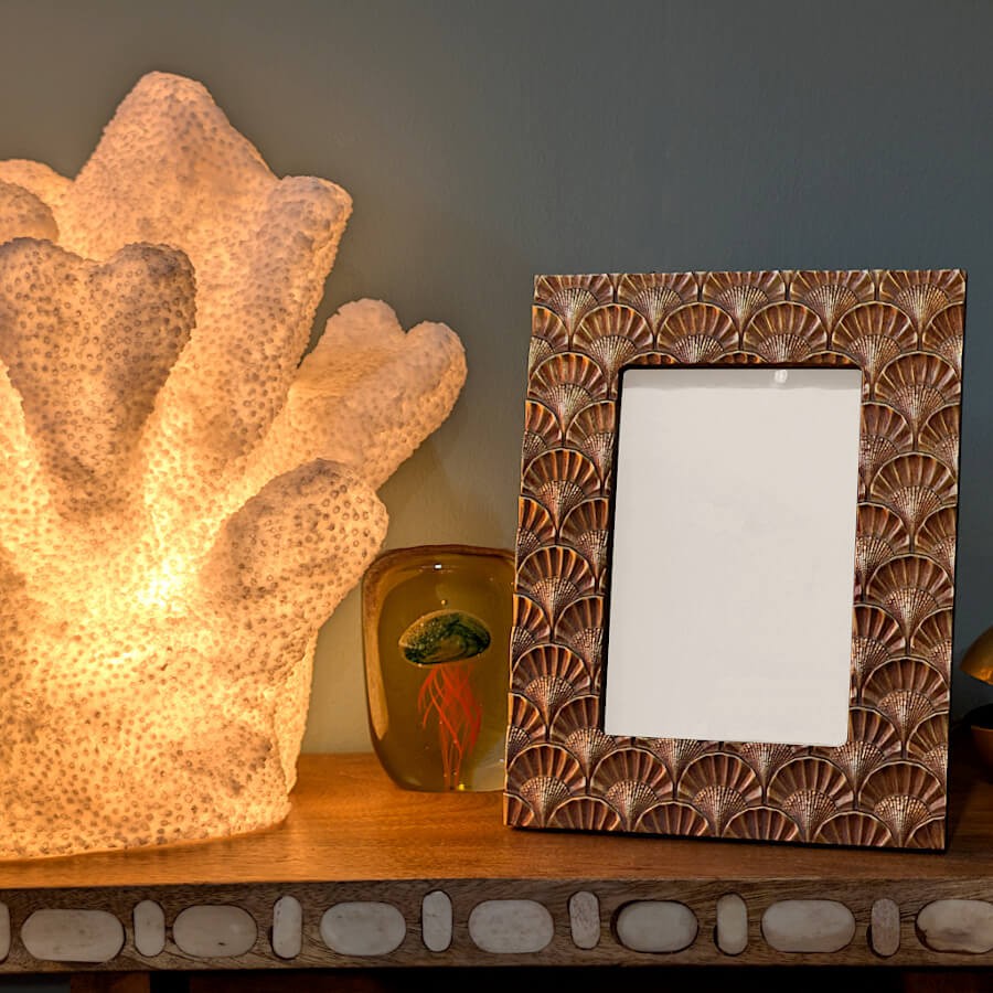 Présentation du cadre sur une console près d'une lampe corail.