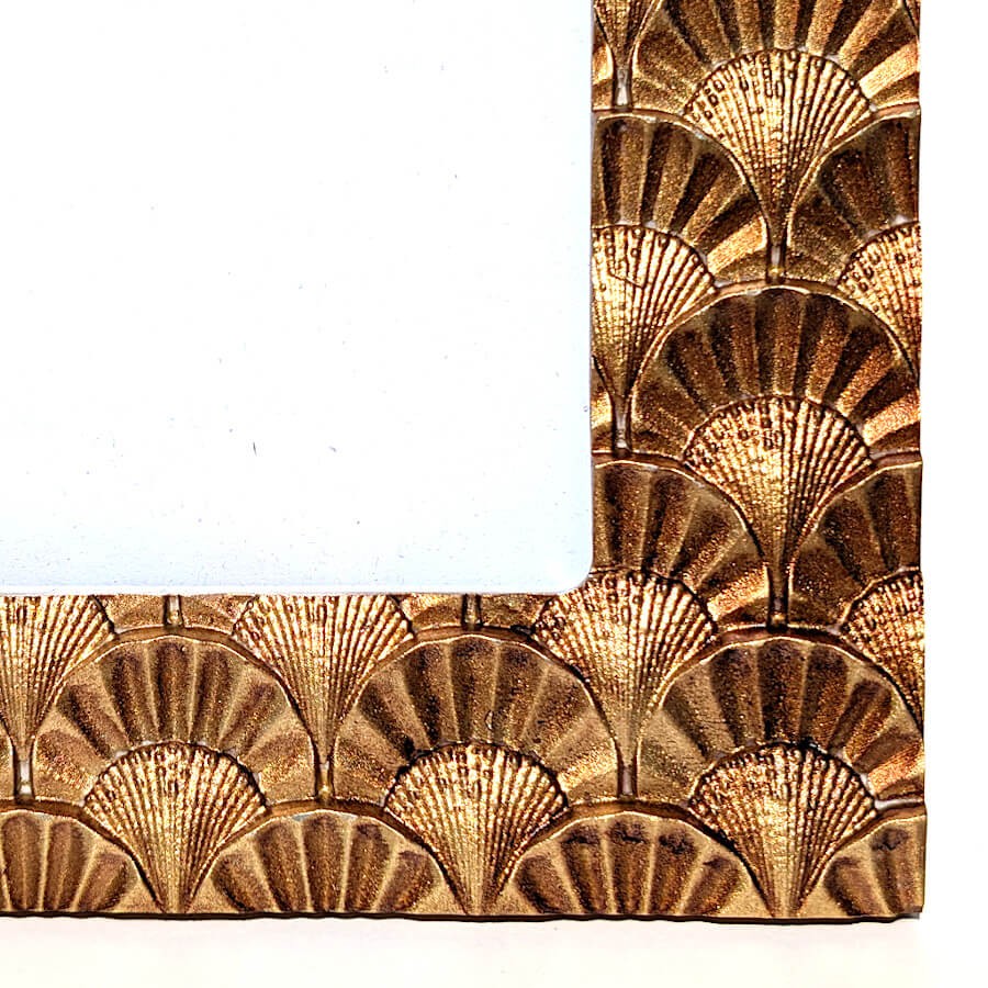 Zoom sur le coin inférieur montrant le détail des éventails sculptés.