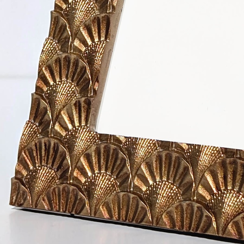 Gros plan macro sur la patine dorée et les stries du motif.