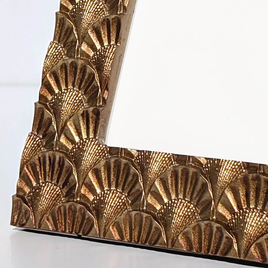 Gros plan macro sur la patine dorée et les stries du motif.