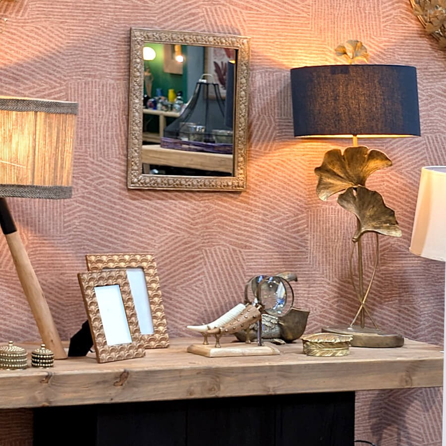 Intégration sur une console en bois avec lampe et accessoires dorés.