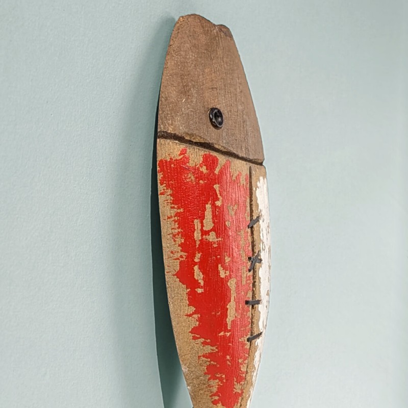 Vue latérale montrant la finesse du bois et la tête stylisée du poisson.