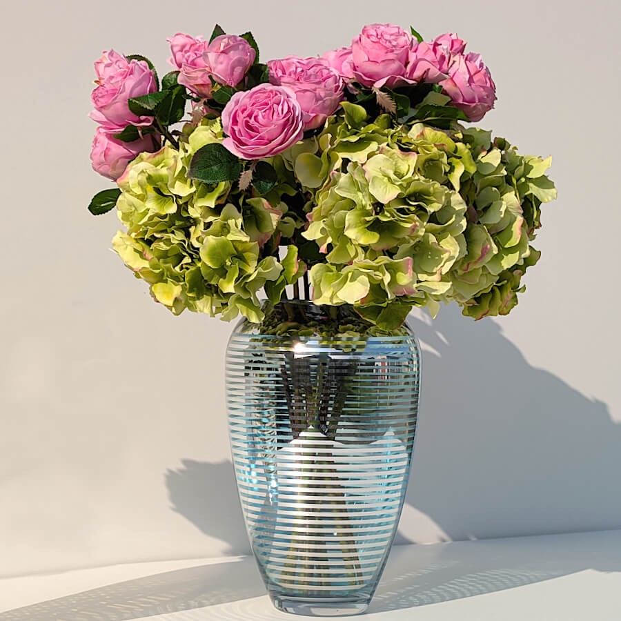 Bouquet mixte associant les roses roses à des hortensias verts dans un vase bleu de la collection Deco-Delight.