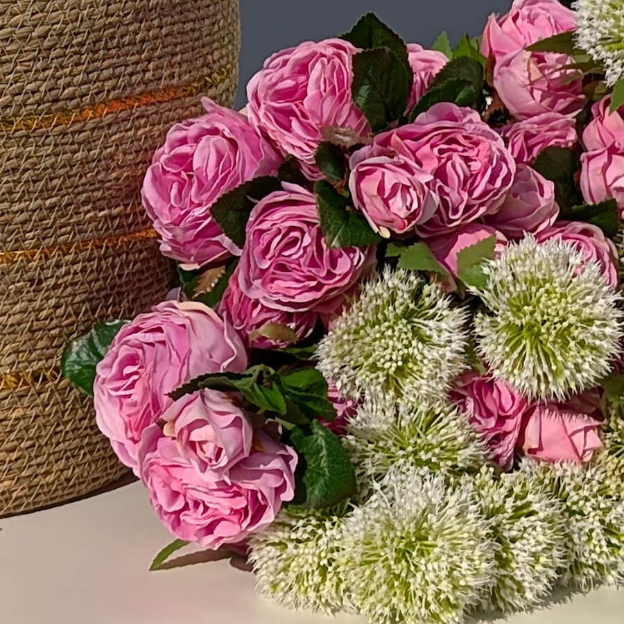 Présentation du bouquet sur une surface claire avec des éléments de décoration naturels.