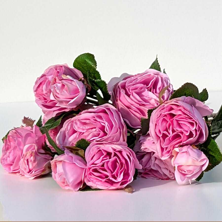 Vue d'ensemble d'un bouquet de roses déposé à plat, mettant en avant le volume des fleurs.