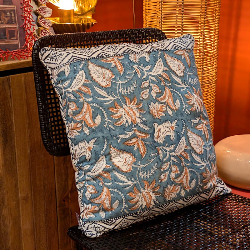 Coussin disposé sur une chaise noire, illustrant le contraste des couleurs.