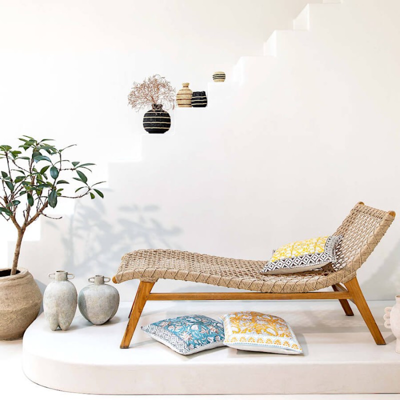 Vue d'ensemble d'un espace détente avec chaise longue et coussins au sol.