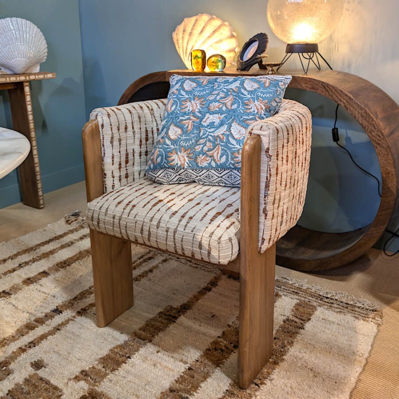 Le coussin intégré dans un décor moderne avec fauteuil en bouclée et arche boisée.