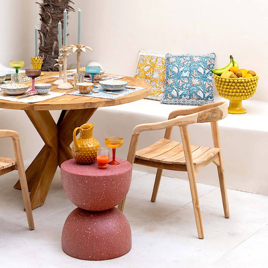 Mise en scène conviviale autour d'une table en bois avec plusieurs coussins.