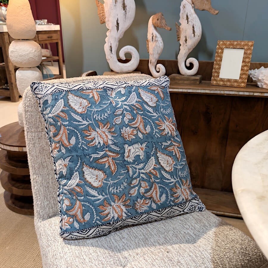 Le coussin sur un fauteuil gris clair, soulignant la douceur du bleu turquoise.