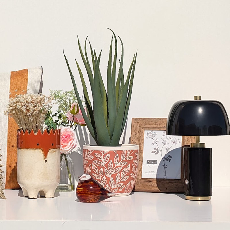 Ambiance bureau chic avec lampe noire, cadre noyer et touches végétales rafraîchissantes, collection Deco-Delight.