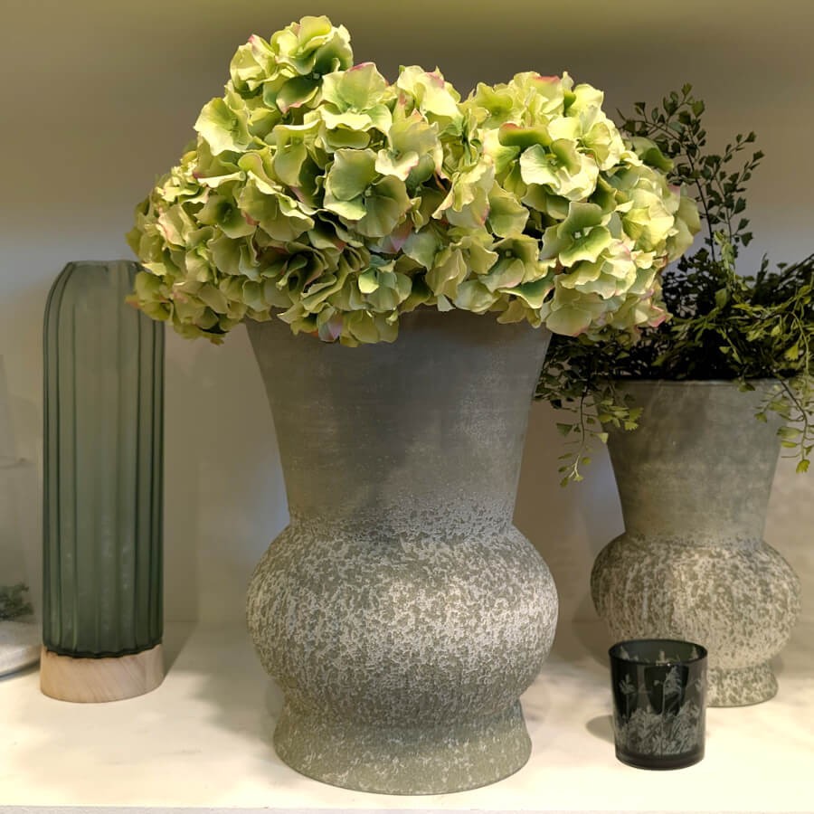 La tige présentée seule dans un grand vase en pierre texturée grise au style minéral.