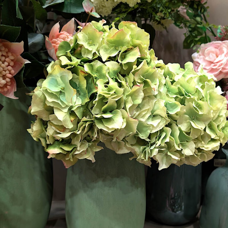 Tiges d'Hortensia artificiel vert nuancé en pot, idéal pour une décoration champêtre et lumineuse.