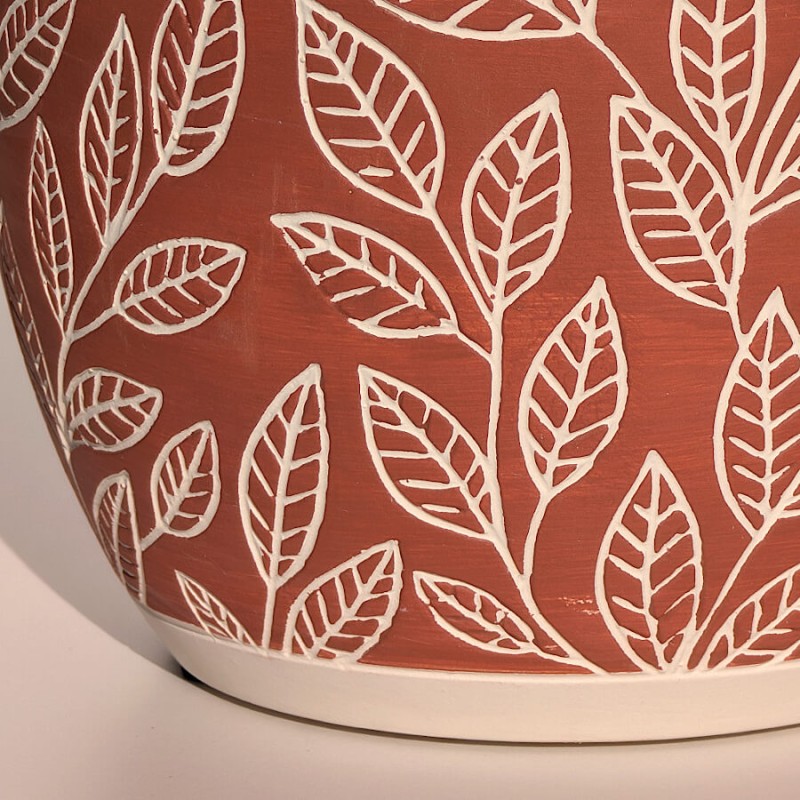 Zoom sur les motifs de feuilles blanches en relief, un design botanique délicat.