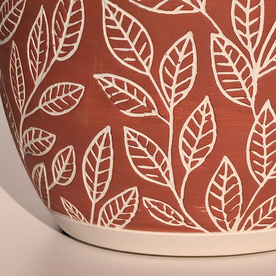 Zoom sur les motifs de feuilles blanches en relief, un design botanique délicat.
