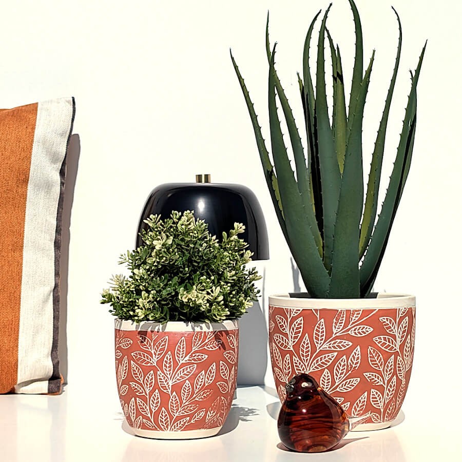 Décoration d'intérieur associant le cache-pot à la lampe LED noire et une statuette oiseau ambrée.