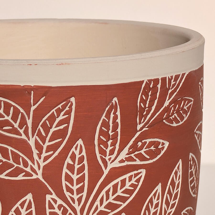 Gros plan sur la collerette blanche et la texture mate de la céramique travaillée.