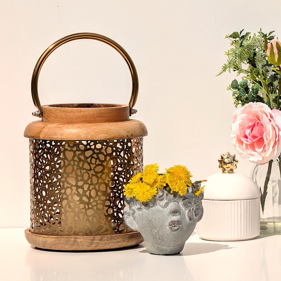 Mise en scène de la lanterne avec accessoires déco pour une ambiance chaleureuse et raffinée.