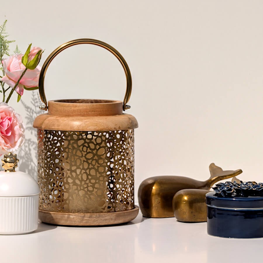 Lanterne en bois et métal mise en scène avec des statuettes de baleines dorées pour un esprit cabinet de curiosités.