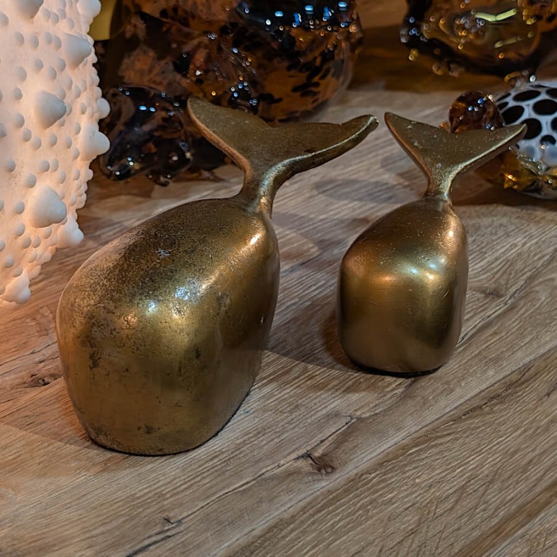 Ambiance chaleureuse avec le duo de baleines en trois-quarts face, disposé sur un plateau en bois naturel.