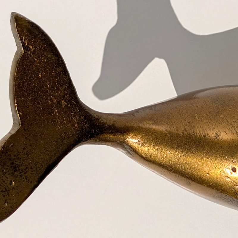 Gros plan sur la queue de la baleine dorée L18 cm, soulignant la finesse de la sculpture et sa patine antique.